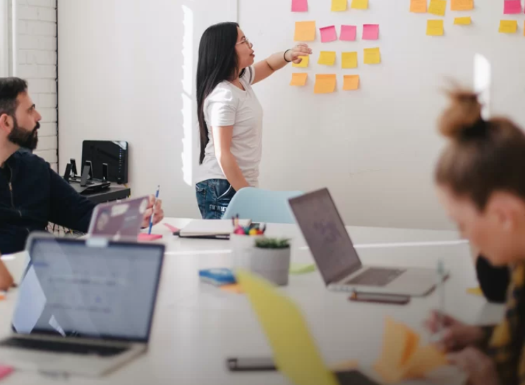 pointing to sticky notes on an idea board