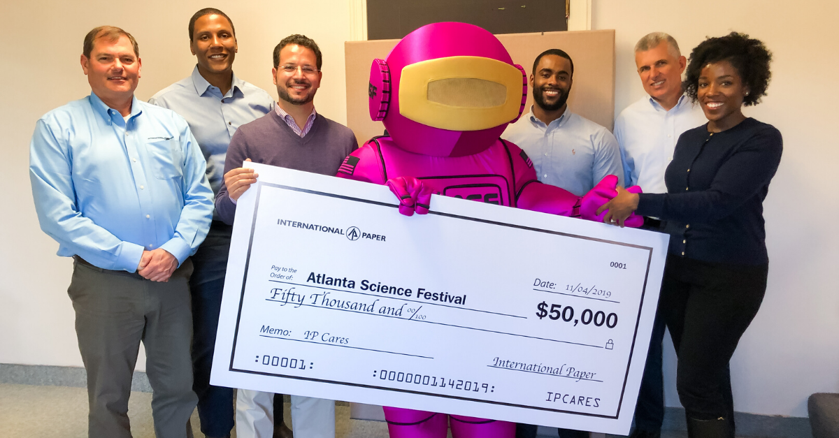 The International Paper team (from left to right: Rick Ayers, Louis Salters, Kelvin Simmons, Tom Wissing, Shantel McClendon) presents the grant to Atlanta Science Festival’s mascot, ALEX, and Jordan Rose, executive co-director of Science ATL.