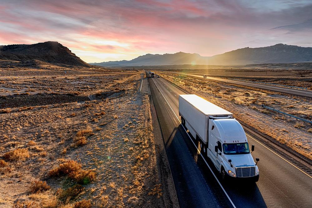 truck driving in the desert at sunset