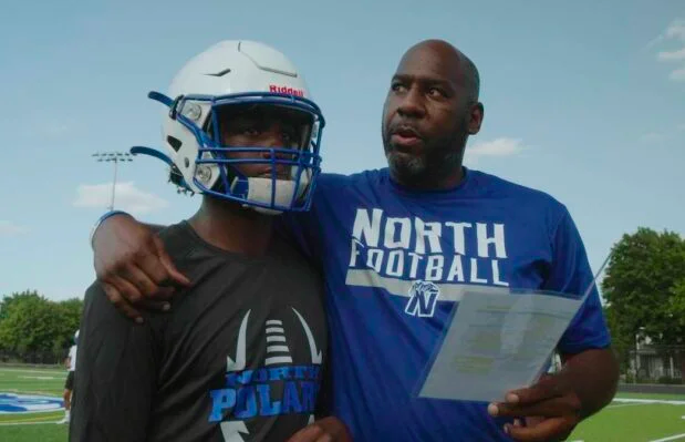 Coach with arm around football player