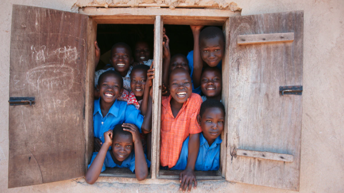 children smiling and sticking heads out window