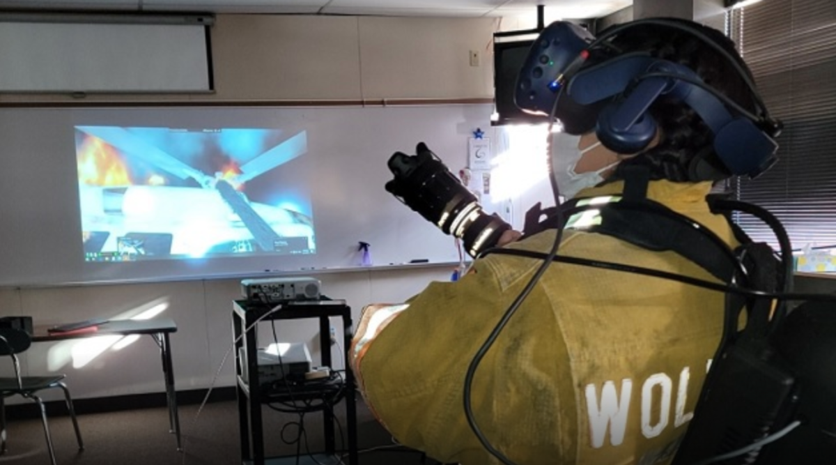 A firefighter douses a digital fire during a VR training session at Pellston Public Schools