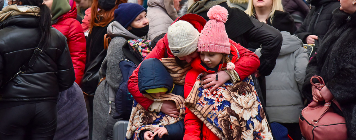 Woman hugging children in a crowd