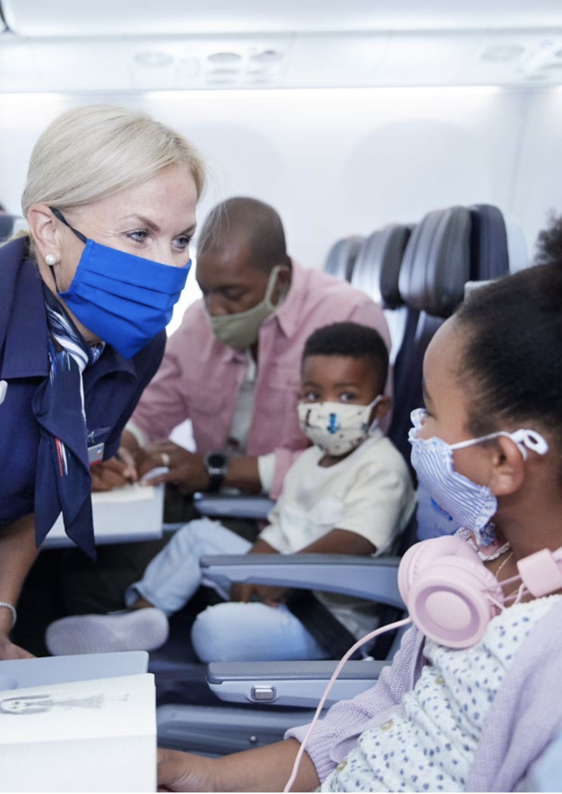 flight attendant assists a Black child
