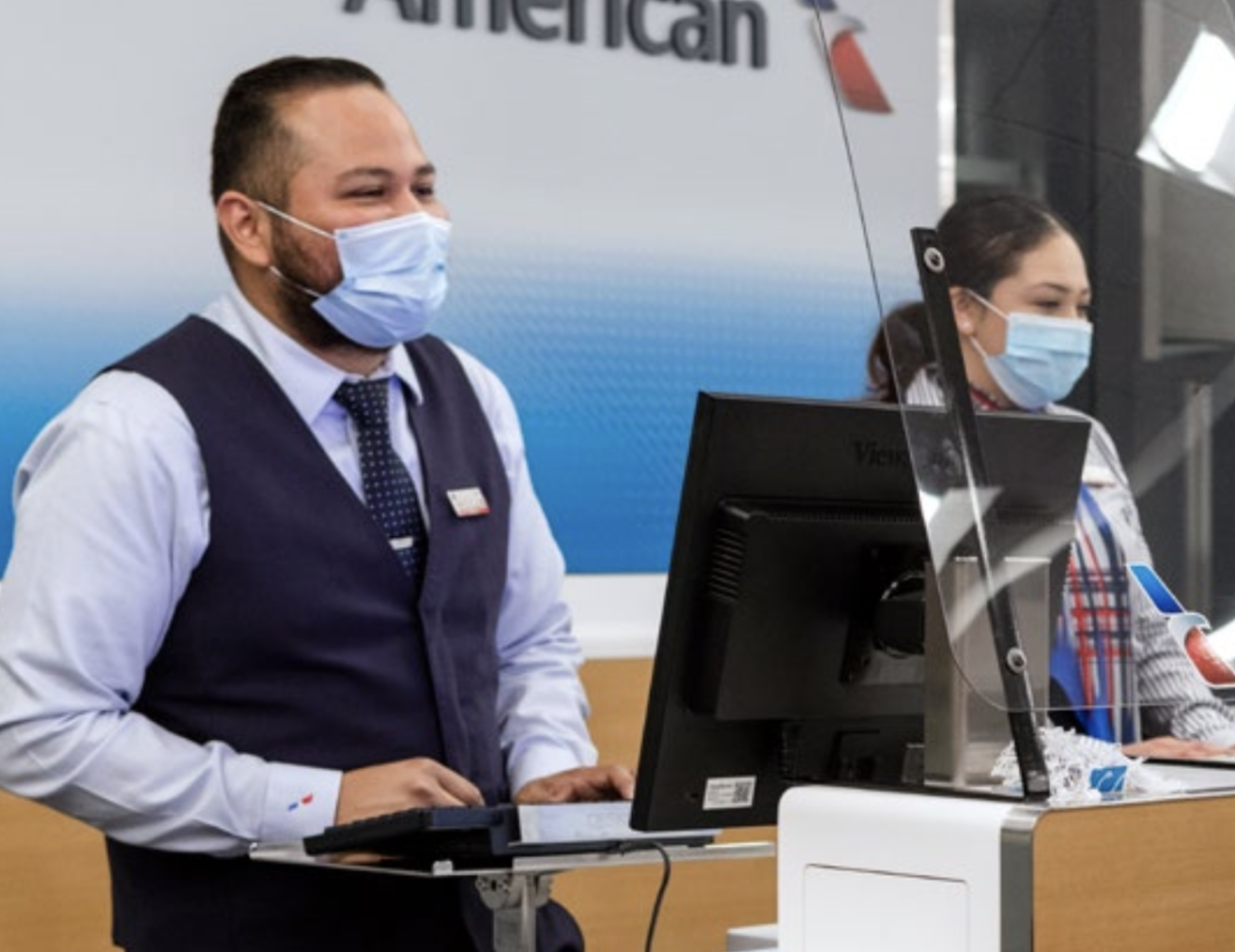 American Airlines gate agents wearing masks and standing behind plexiglass