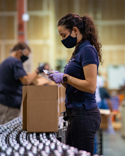 Person packing food in assembly line