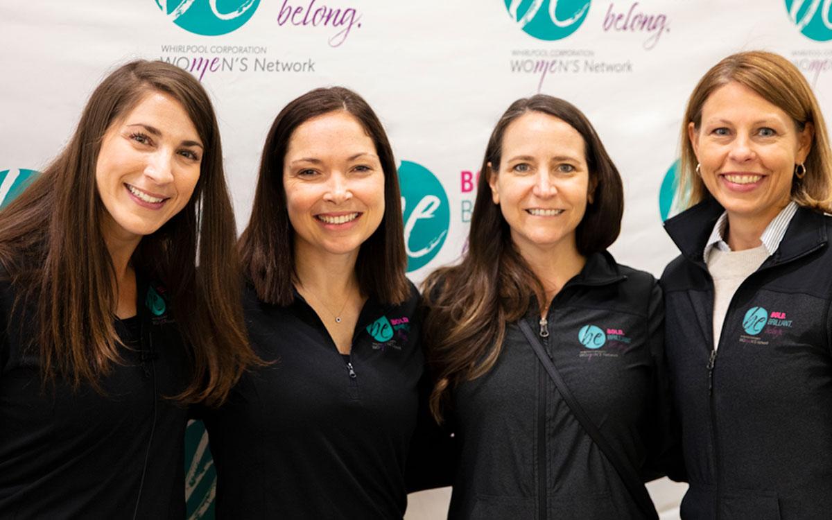 a group of 4 people including Lynn Moersch wearing matching jackets with "Be" logo