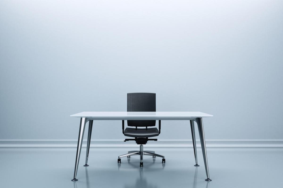 Desk and chair in the center of an empty room