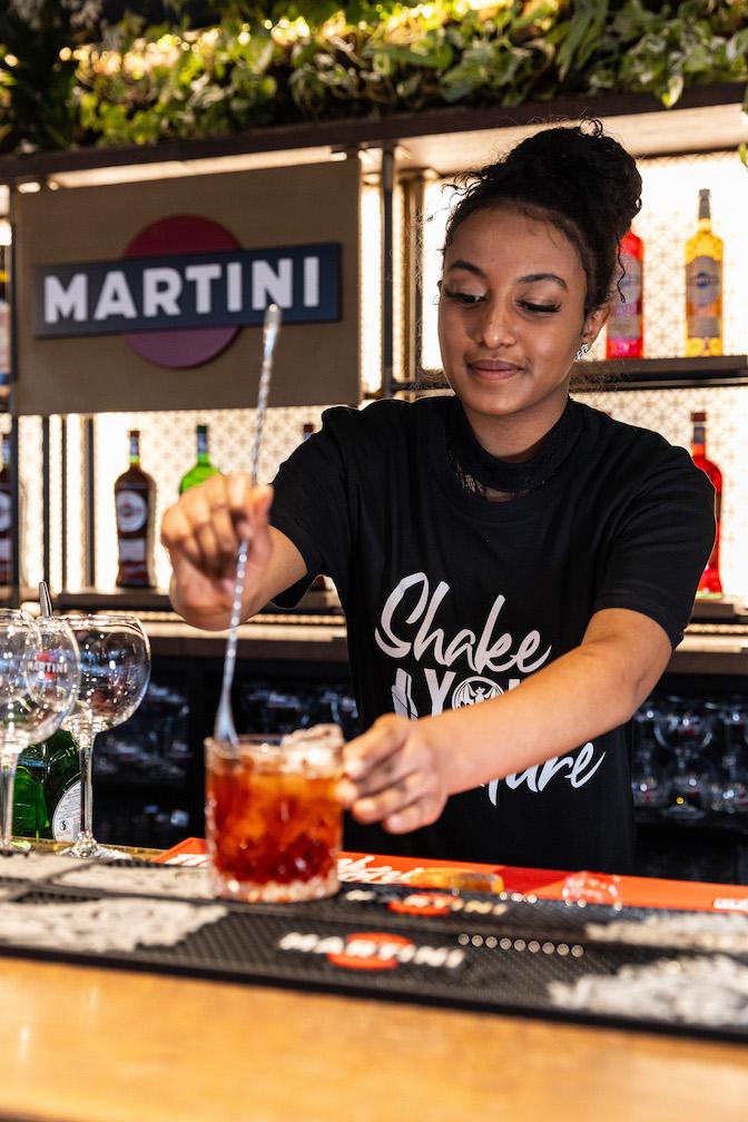 A person making a drink at a bar