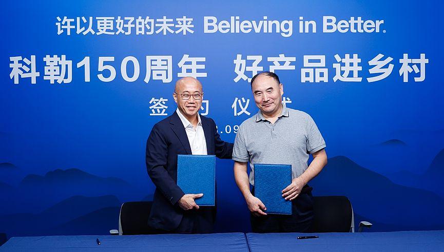 Two people stood together against a blue backdrop 