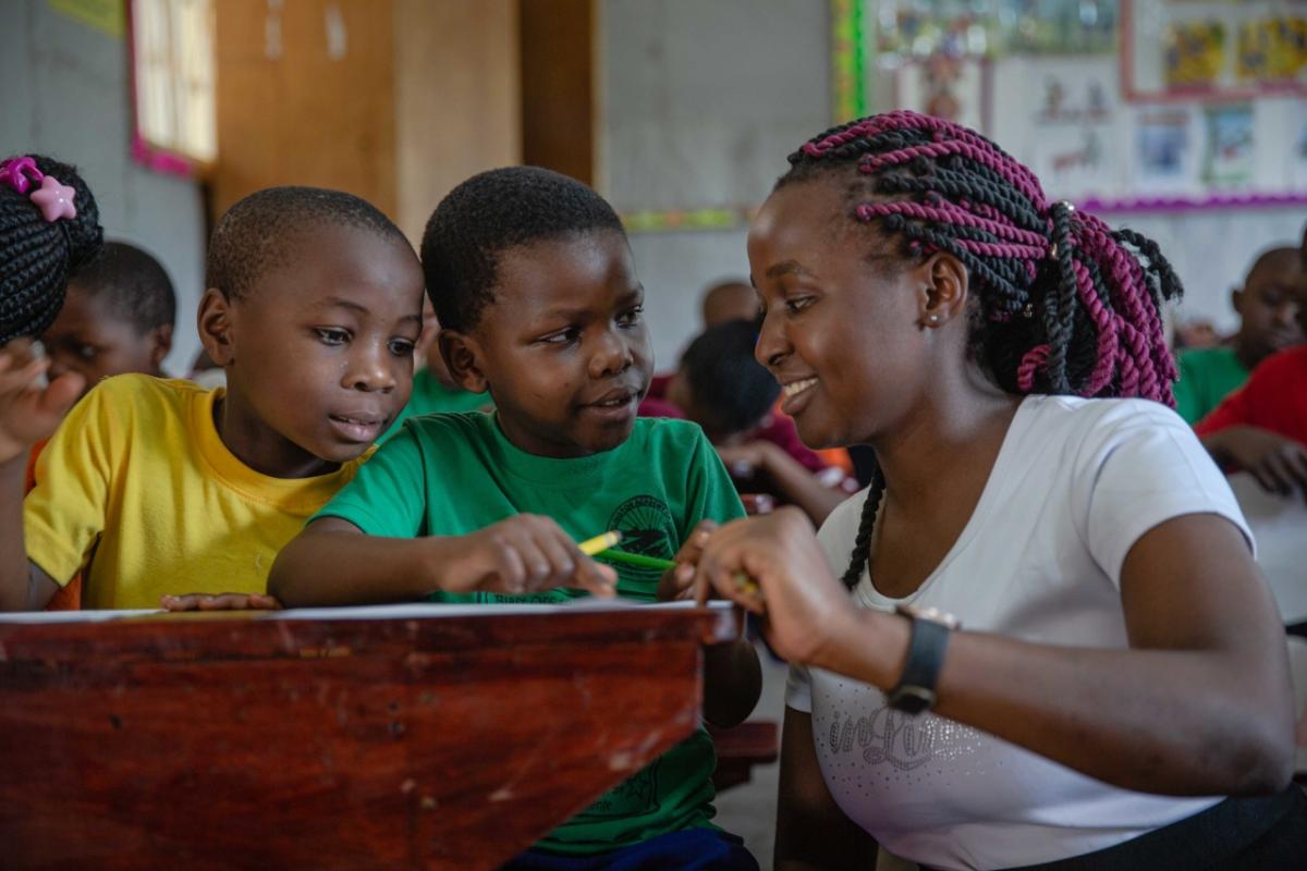 A teacher helping students at a desk