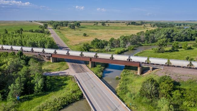 Train traveling on track through verdant landscape
