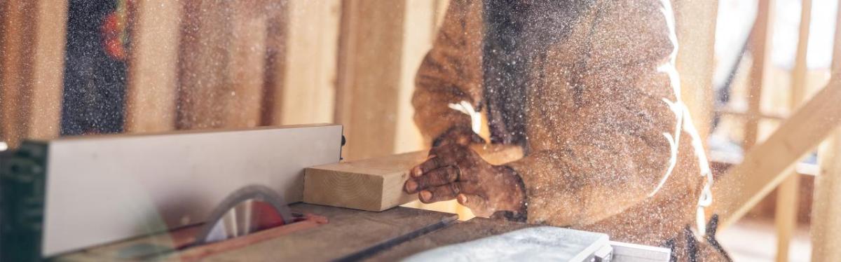 A person cutting some wood using a machine 