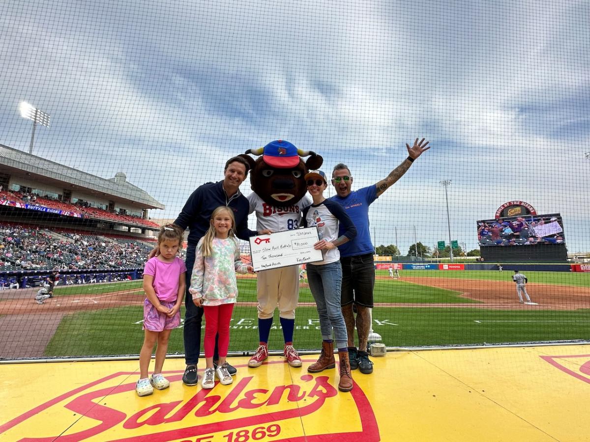 Slow Roll Buffalo donation shown with Buffalo Mascot and a family.