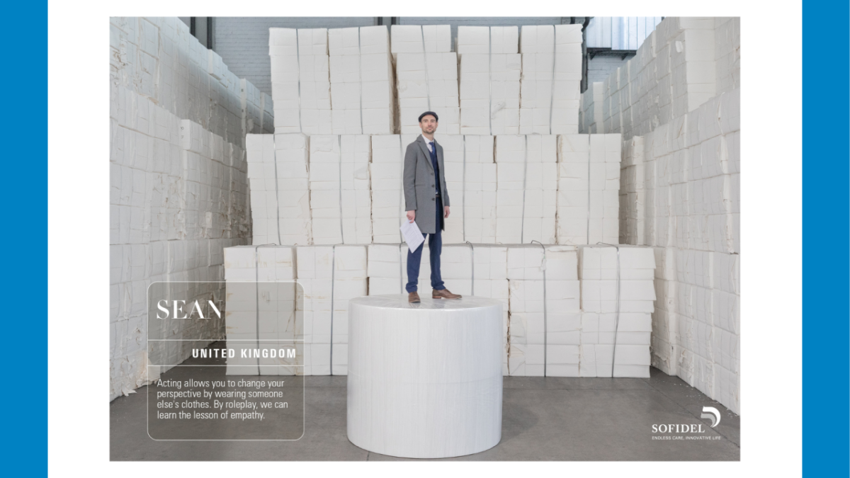 Image of man standing among stack of paper