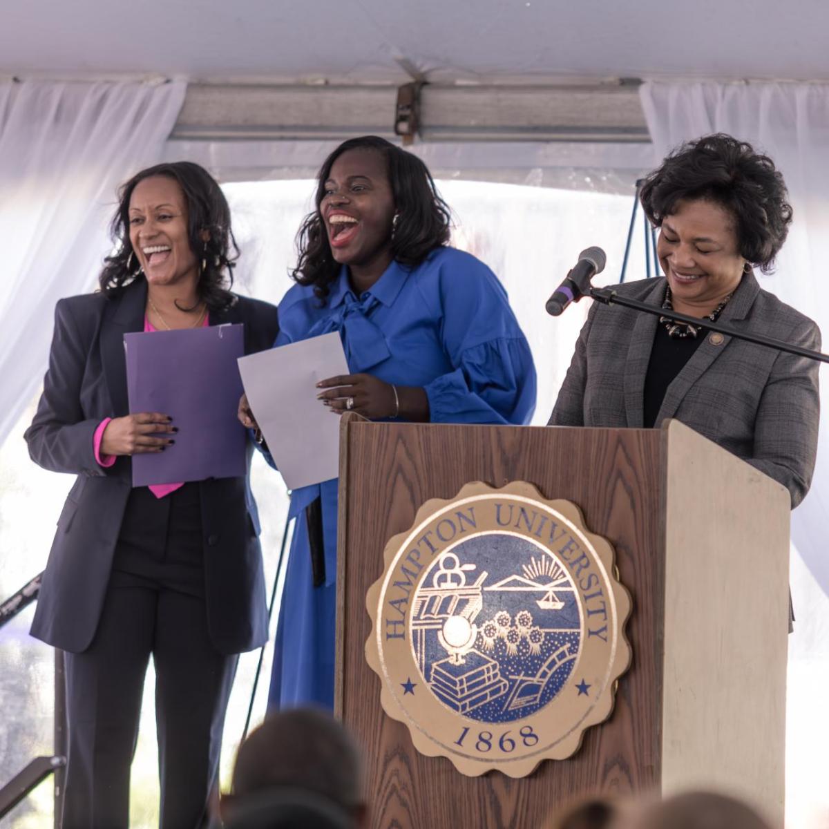 3 people at a podium during ceremony 