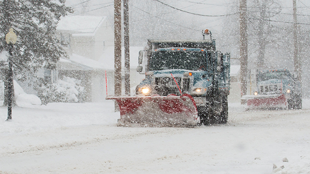 Plows clearing snow during a severe storm.