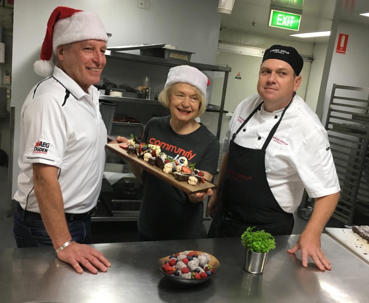 Suncorp Stadium General Manager Alan Graham (left), Communify Chair Carolyn Mason and O’Brien Group Australia Executive Chef, Bevan Campbell, get into the Christmas spirit ahead of the Christmas Day lunch at the stadium this year.