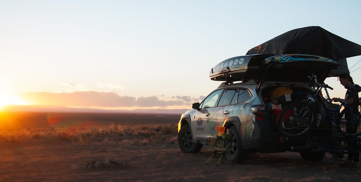 A parked car facing towards the sun setting