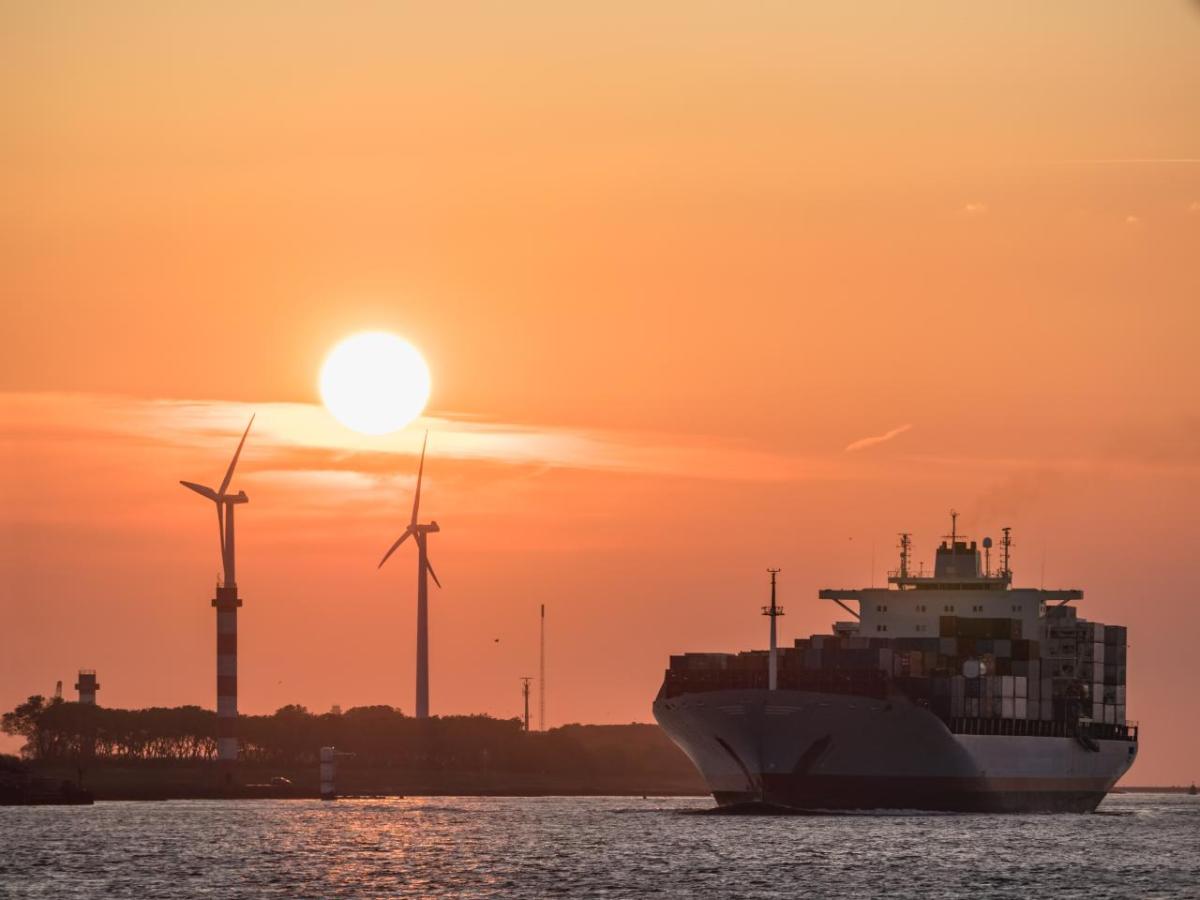 Container ship coming into port at sunset
