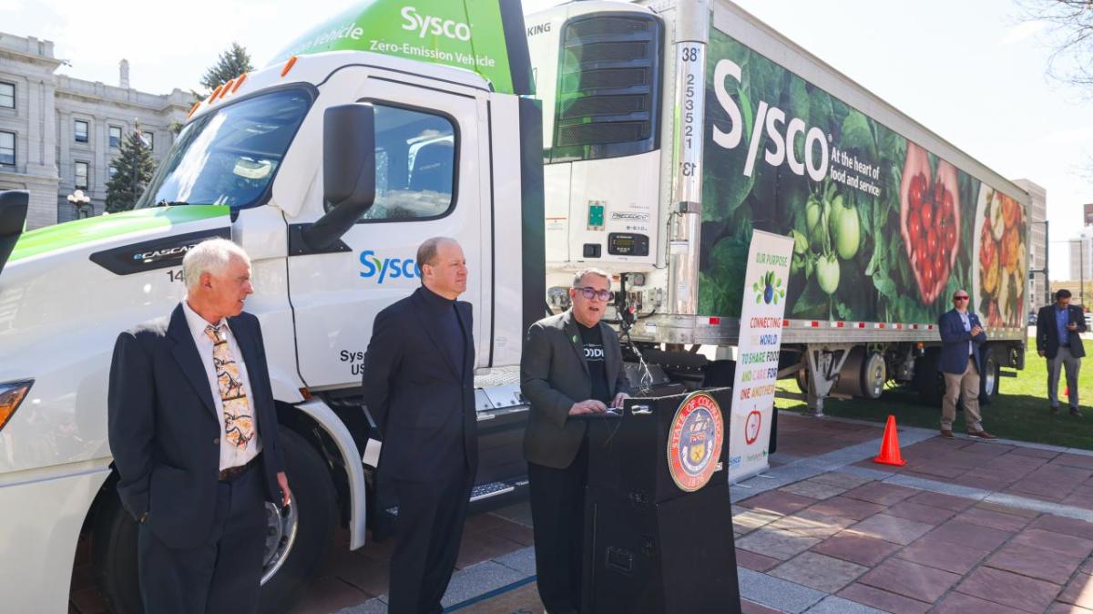 People standing by the side of a truck