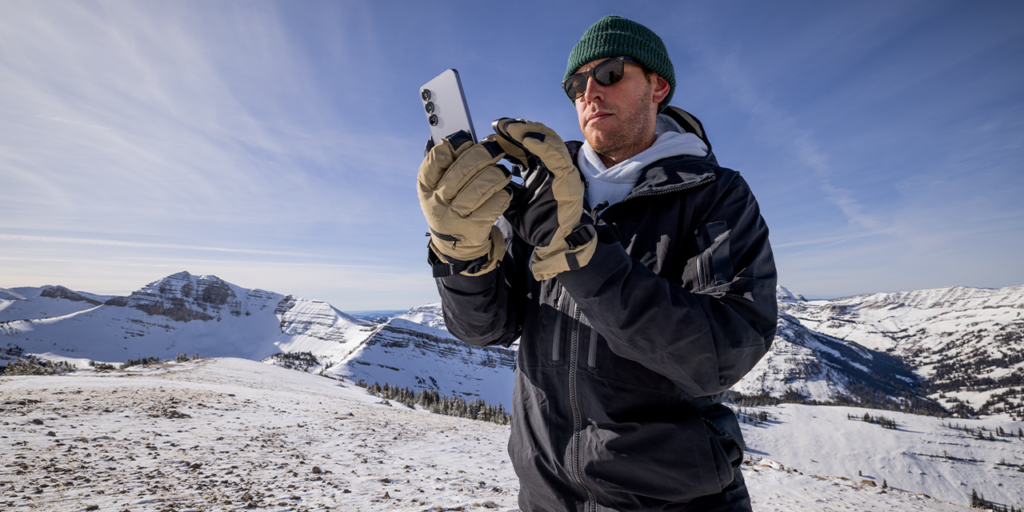 Jimmy Chin looking at phone on mountaintop
