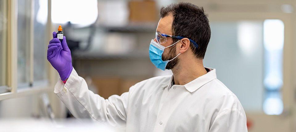 Scientist looking at a vial