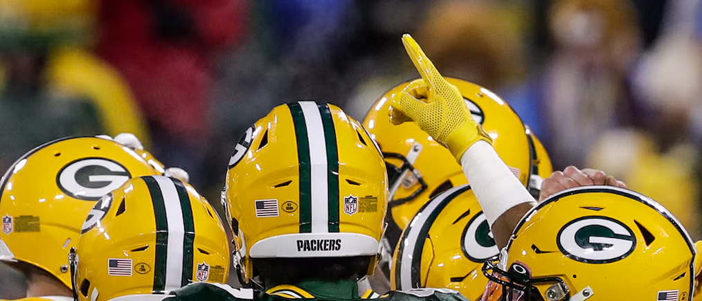 Green Bay Packers shown in a huddle.