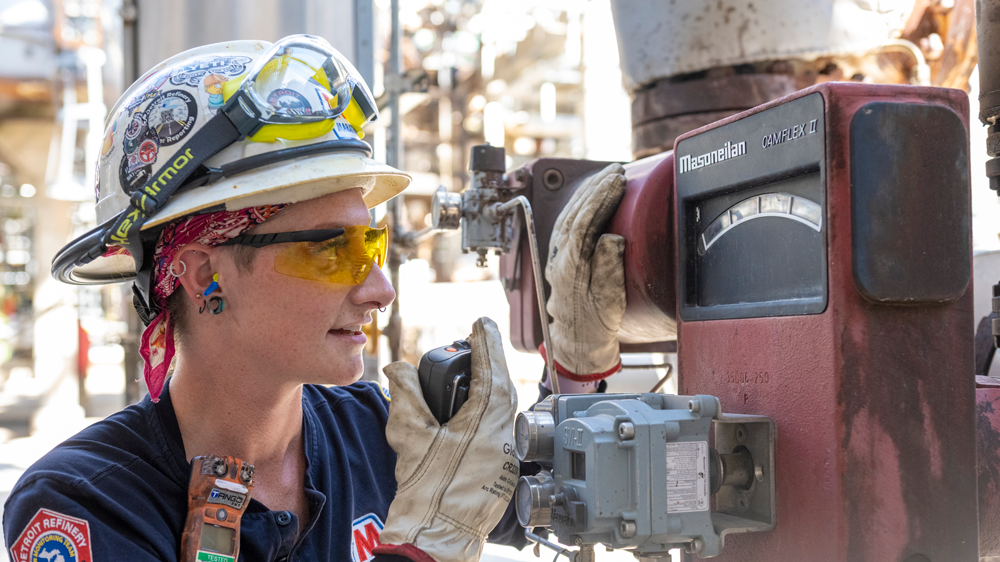 Tara Chippewa using a radio communicator while looking at a meter.