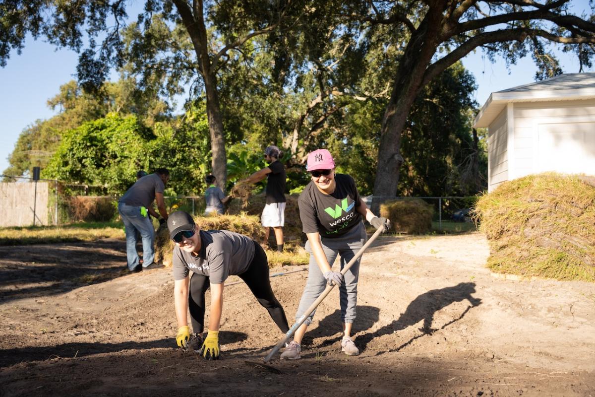 Wesco volunteers raking in the yard.