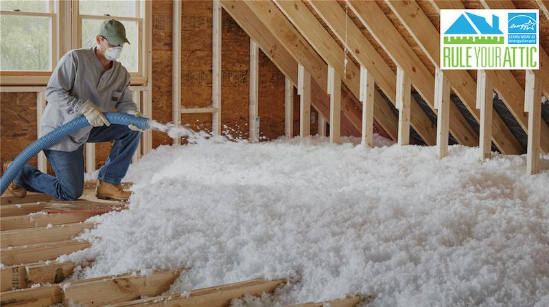 ENERGY STAR: Rule your attic. Worker shown blowing in insulation into an attic space.