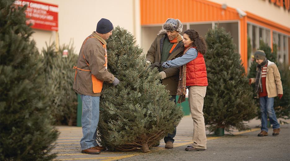 Family selecting a Christmas tree at Home Depot.
