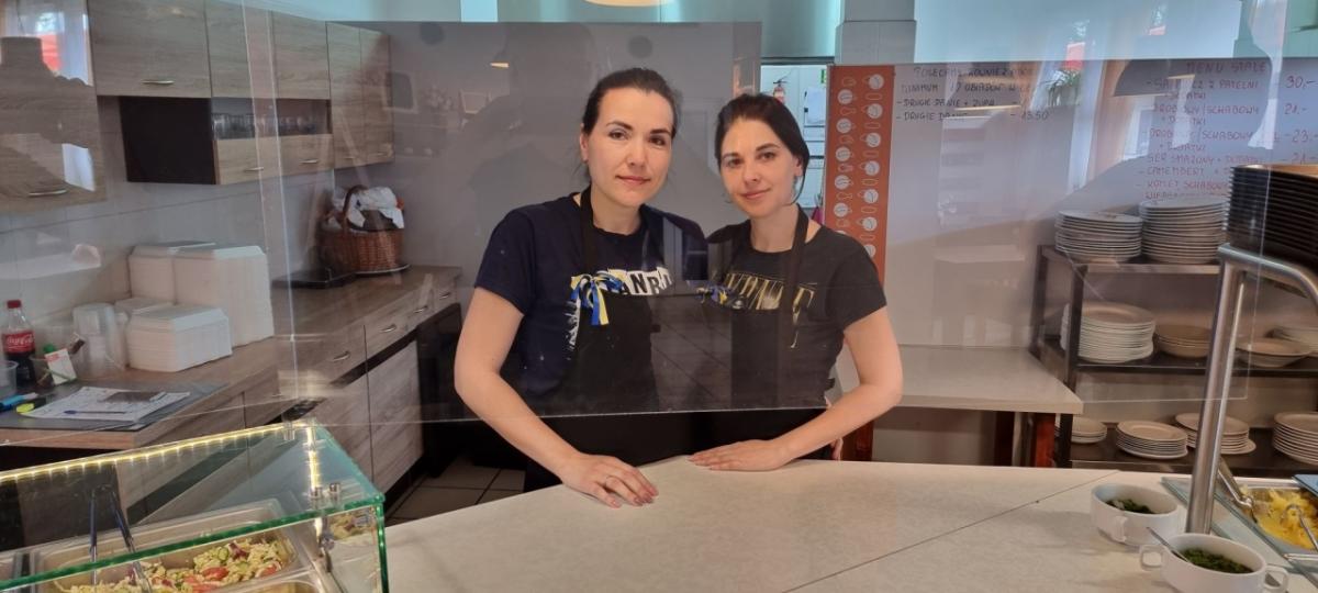 2 people in the kitchen of a restaurant