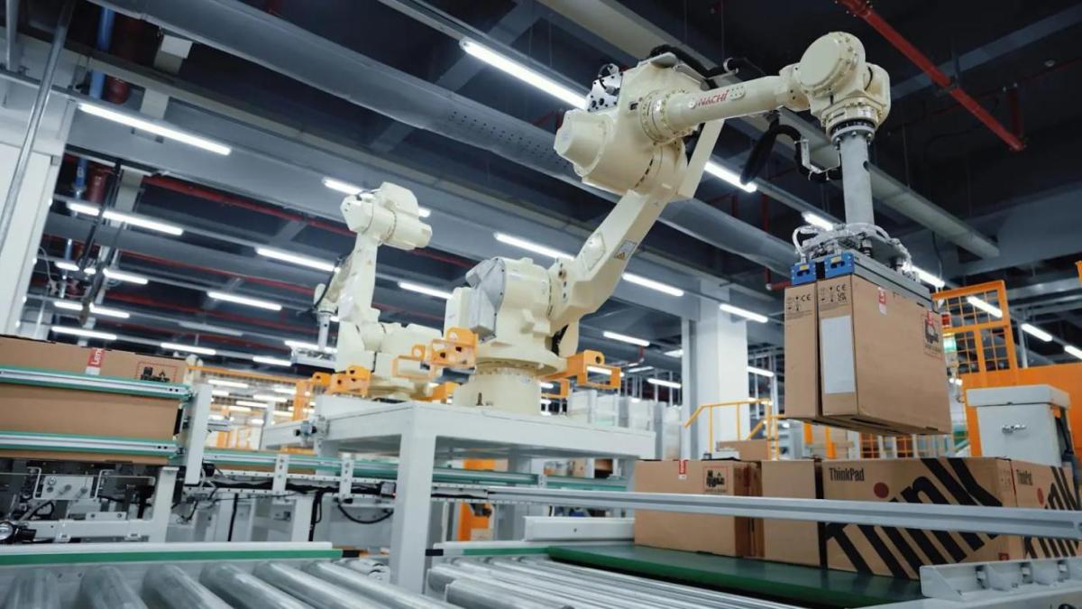A robotic arm lifting a box in a large facility