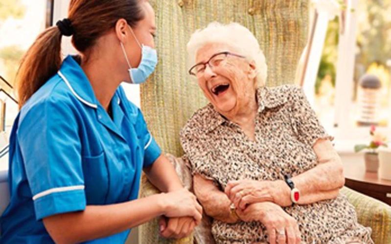 Nurse assisting an elderly woman.