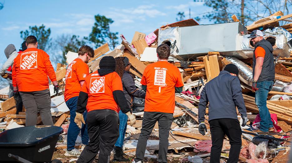 Destruction by a tornado shown. Members of Team Depot shown at the disaster site.