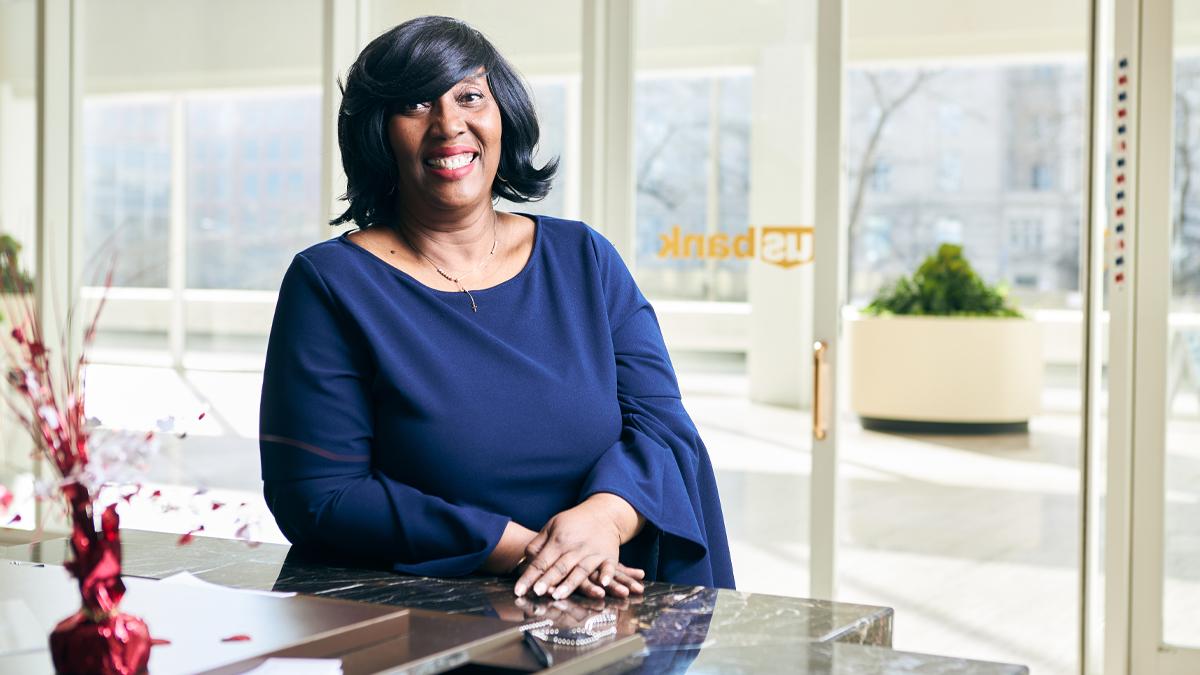 Tracy Egerson, who is part of a U.S. Bank program to create future mortgage leaders who represent all the communities the bank serves, at her Milwaukee office. Tracy Egerson leaning on a dark marble counter. Large windows behind her.