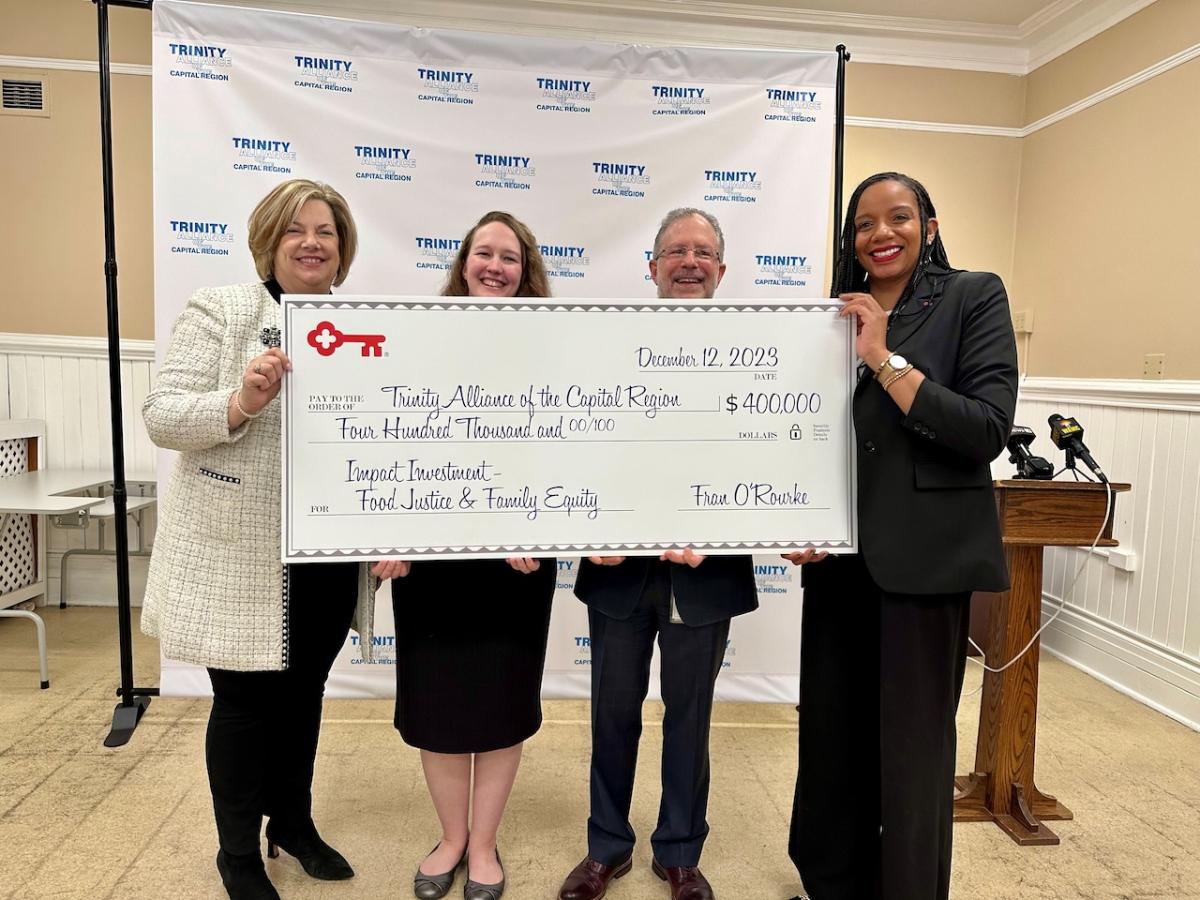 KeyBank and Trinity Alliance team members shown holding a $400,000 grant check.