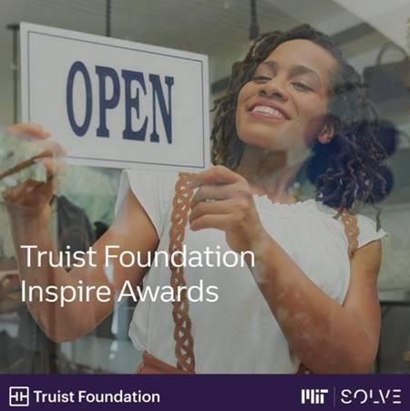 Woman holding Open sign with text "Truist Foundation Inspire Awards"