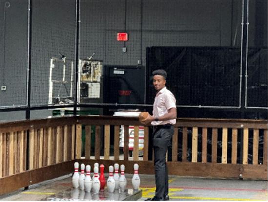 Truman holding a ball next to bowling pins.