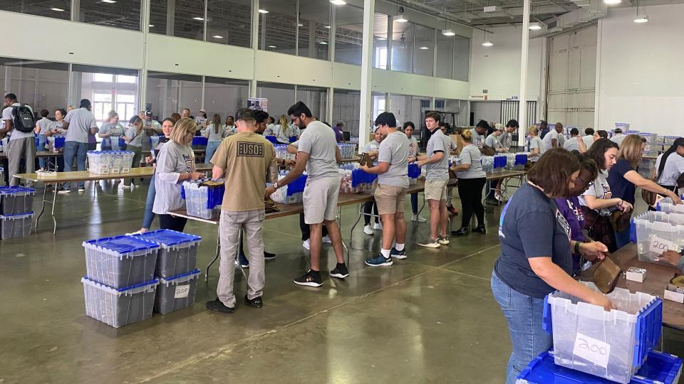 People organized at tables assembling kits.