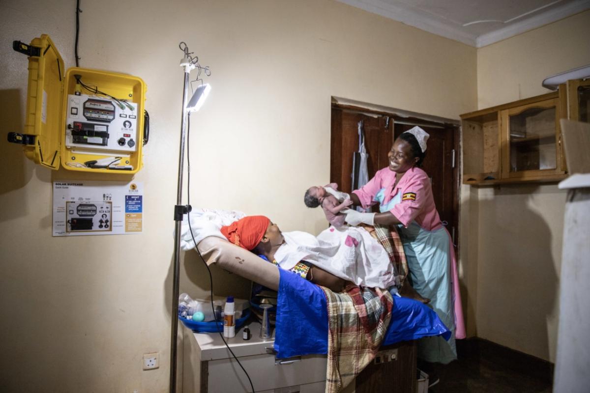 Health worker delivering baby in hospital, Uganda