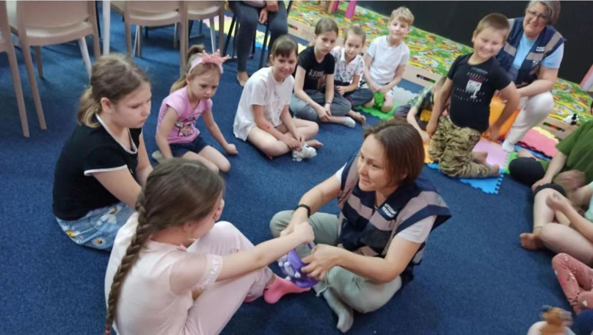 A Ukrainian emergency psychologist interacts with children in a flood-affected community. (Melinda Endrefy/Hromada Hub)