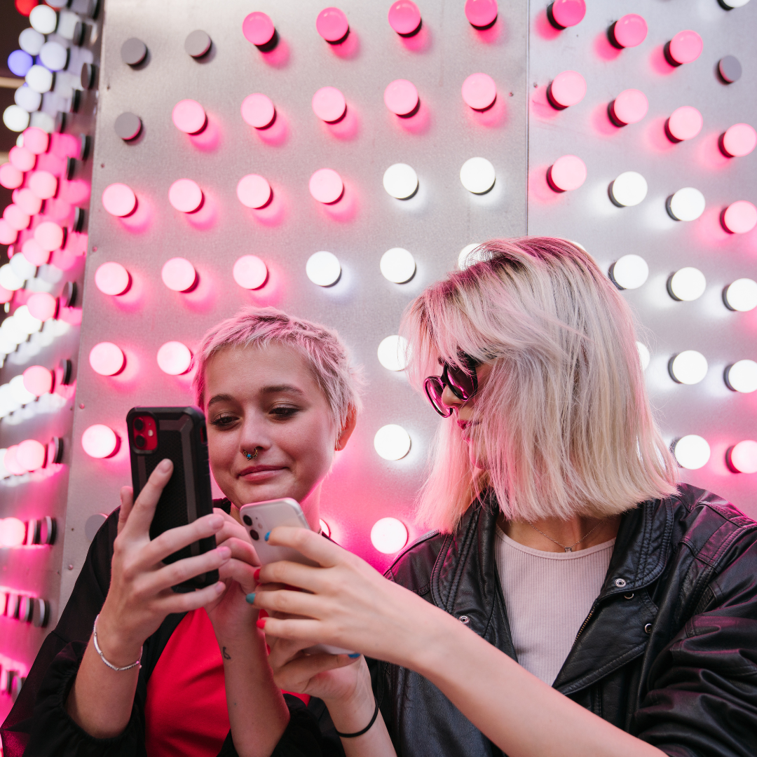 Two young women looking at cell phones