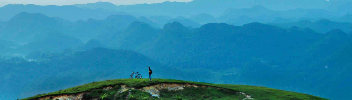 Biker ponders mountain landscape
