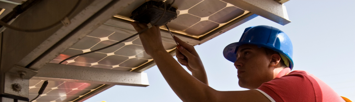 Construction worker installing solar panel
