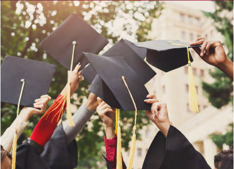 Hands holding graduation caps in the air.