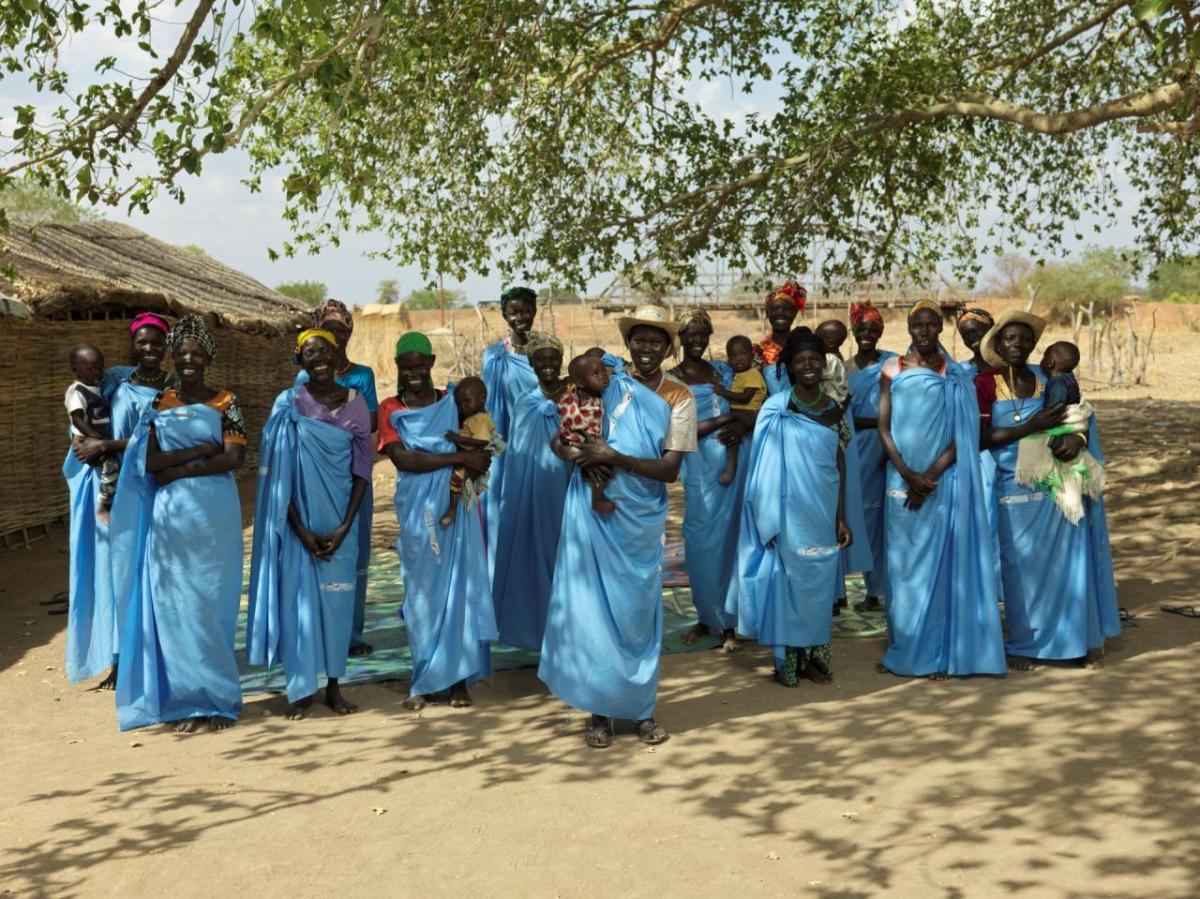 Women wearing blue smile for a photo. 