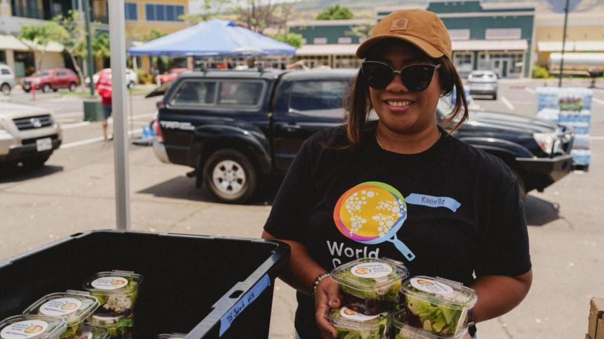 Person holding multiple salad boxes