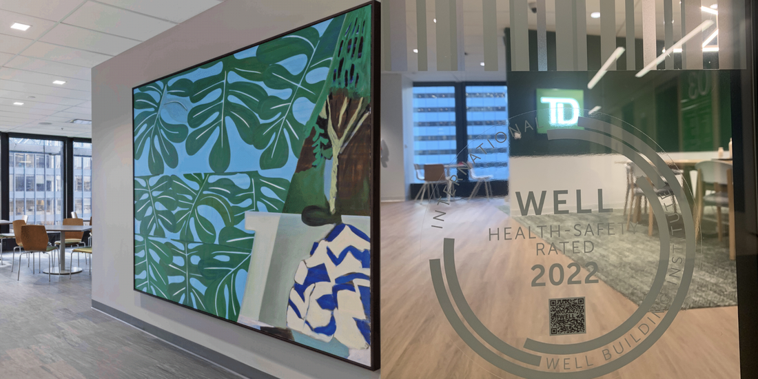 Interior walls of a TD Bank location, the WELL seal emblem on a glass wall